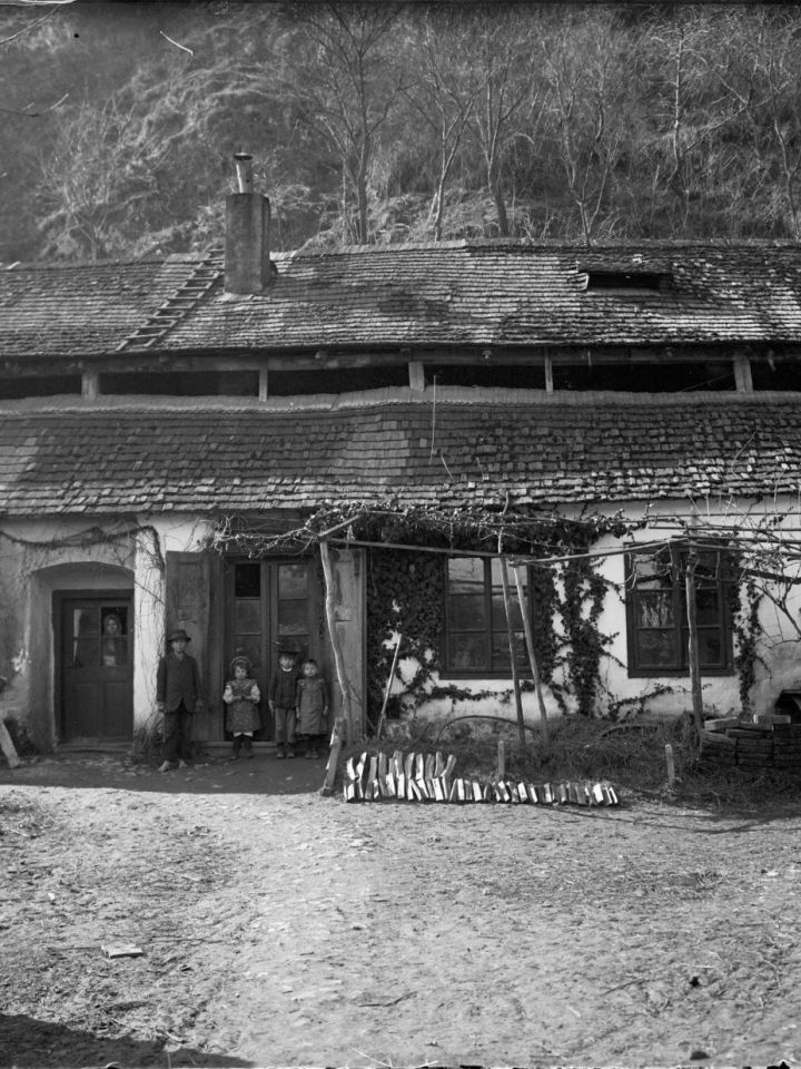A Benedek-hegy sziklatömbjéhez simuló tobakház és lakói 1909-ből. LDM Fotótár 2717.