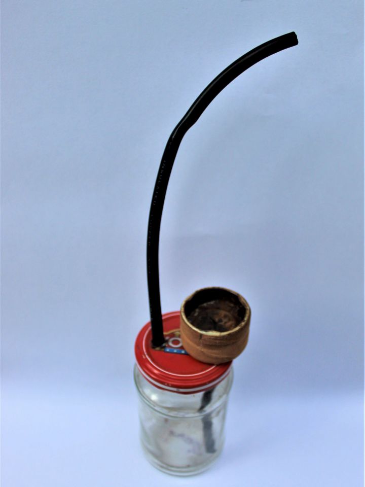 Házilag készített pipa, tormás üvegből, benzincsőből és sebtapasszal megerősített fém dohánytartóval. Ltsz: 2011.04.01.