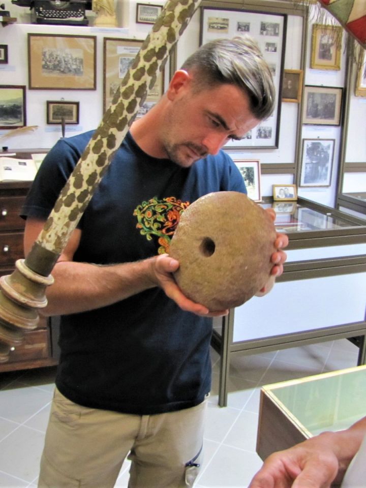 Régész kollégánk egy vörös homokkőből faragott, vélhetően festék őrlésére szolgáló eszközt tanulmányoz.