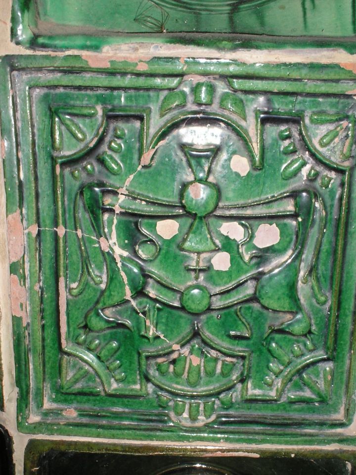 A rekonstrukció során valamiért fejjel lefele beépített, szintén népszerűnek számító, „címeres” kályhacsempe a csicsói Agyaglikról. 