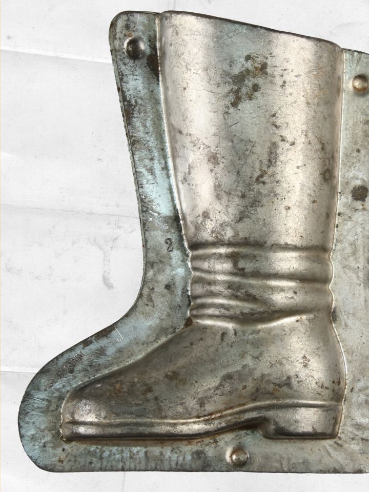 Csizma alakú, „Obermann” márkajegyű öntőforma. Peremmel együtt 18 cm magas, 13,5 cm széles a forma, tehát meglehetősen nagy csokoládéfigura készült a segítségével. Az előbbiekhez hasonlóan V. Fodor Zsuzsa gyűjtéséből.