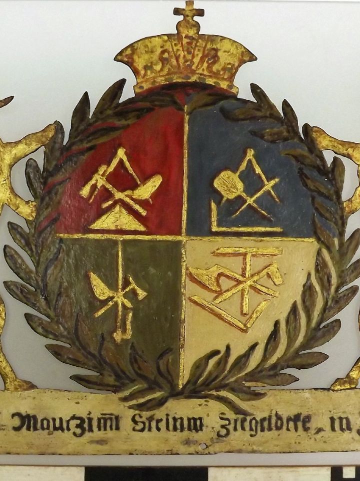 A zirci kőműves, ács, cserepes, kőfaragó vegyes céh 1823-ból való céhtáblája. Festett vaslemez.