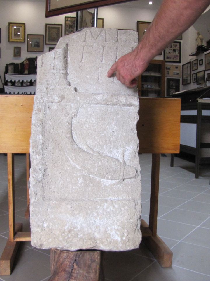 Delfinábrázolással díszített római sírkőtöredék. A Dörgicsén talált sírkő, valamint annak alsó részéhez képest ennek szövegezése kidolgozottabb, olvashatóbb, alaposabb munka…