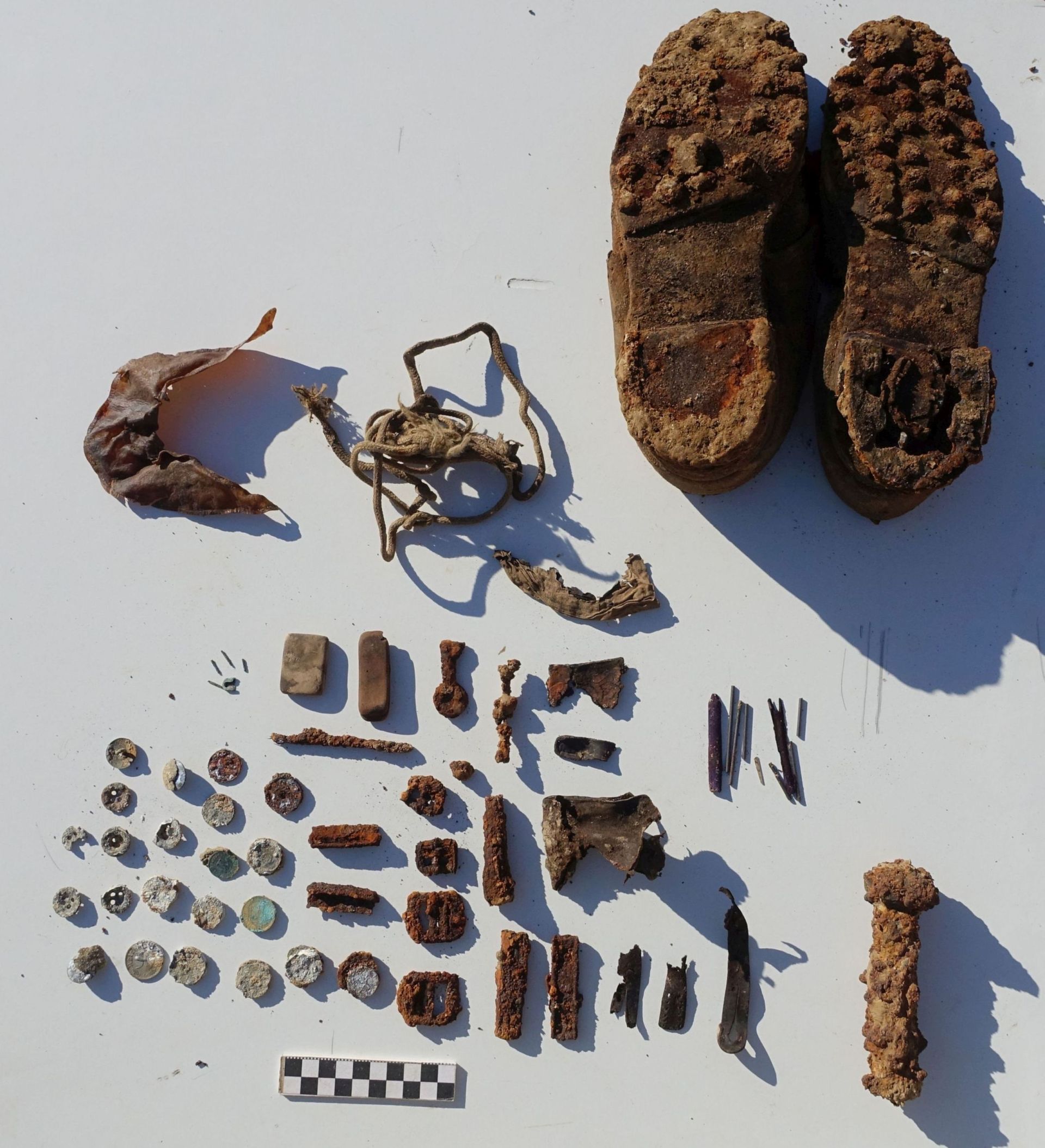 német katona sírmellékletei: zubbony gombok,radír, kulcs, ceruza,MG 42-es géppuska závár, pénzek, töltősín STG-44-es rohamkarabélyhoz, M43 tábori sapka simléderének belső merevítése